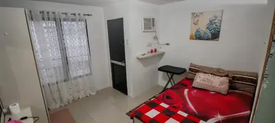a small room with a red bed and a window at Balai Staycation in Imus