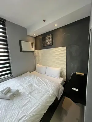 a bedroom with a large bed with white sheets at Antel Spa Residences 2602 in Manila