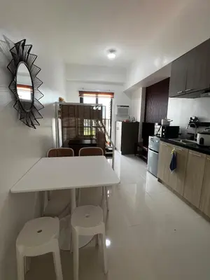 a kitchen with a table and stools in a room at Modern Studio with Balcony and City View Near BGC in Manila