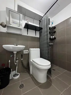 a bathroom with a toilet and a sink at Modern Studio with Balcony and City View Near BGC in Manila