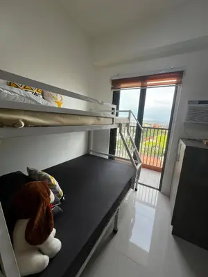 a bedroom with a bunk bed and a balcony at Modern Studio with Balcony and City View Near BGC in Manila