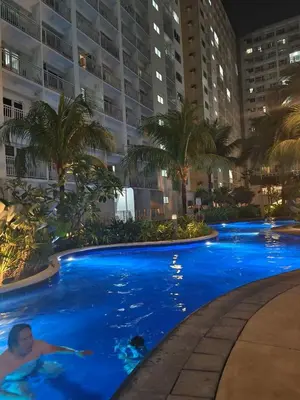 a man in a swimming pool at a hotel at 2 ROOMS 1 UNIT by Metro Staycation in Manila