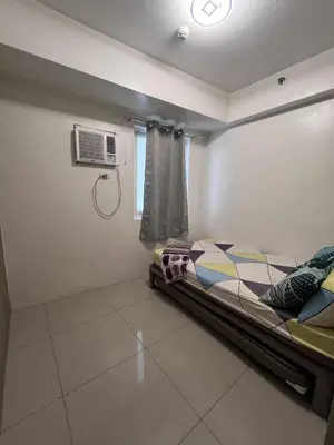 a bedroom with a bed and a air conditioner at 2 ROOMS 1 UNIT by Metro Staycation in Manila
