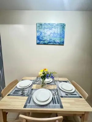a wooden table with plates and flowers on it at Gambino Homes in Manila