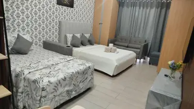 a bedroom with a bed and a couch and a chair at Gambino Homes in Manila
