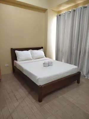 a bedroom with a bed with two cups on it at Gambino Homes in Manila