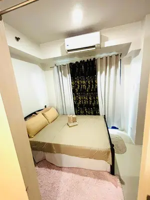 a small bedroom with a bed and a window at RE Staycations MOA VIEW in Manila