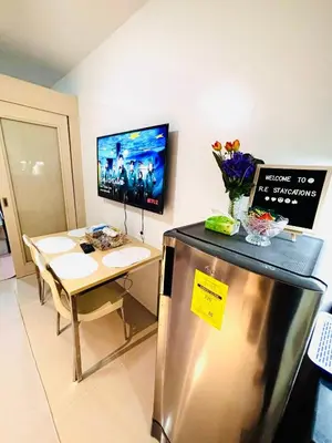 a kitchen with a stainless steel refrigerator and a table at RE Staycations MOA VIEW in Manila