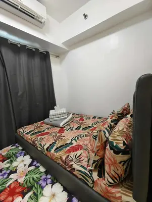 a bed in a room with a comforter on it at Sea Residence by una in Manila