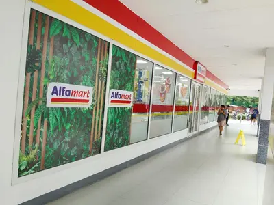 a woman walking down a hallway in a mall at Sea Residence by una in Manila
