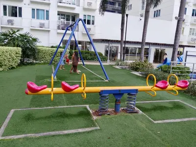 a playground with a slide in a park at Sea Residence by una in Manila
