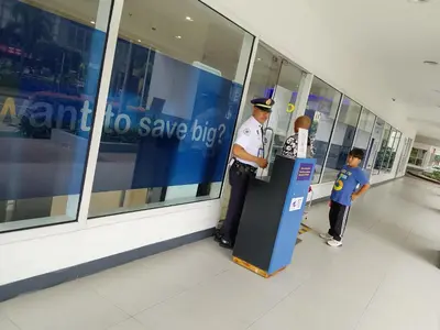 a police officer standing next to a machine in a mall at Sea Residence by una in Manila