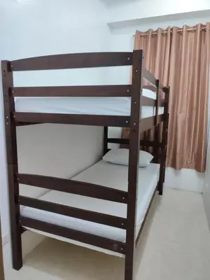 a wooden bunk bed in a room with a window at Stay Manila Hostel in Manila