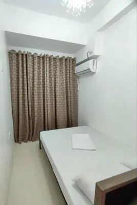 a white room with a bed and a window at Stay Manila Hostel in Manila