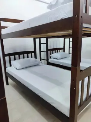 two bunk beds in a room with white sheets at Stay Manila Hostel in Manila
