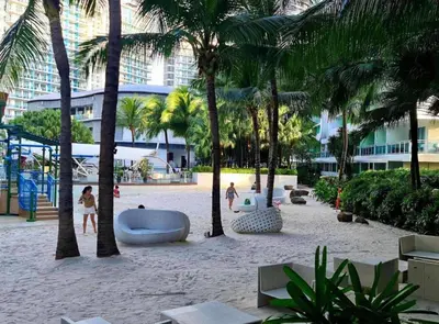 a beach with palm trees and a volley ball court at Azure Urban Resort Residences in Manila