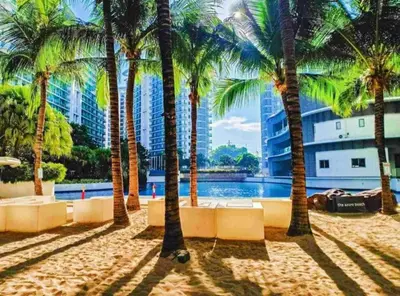 a resort with palm trees and a swimming pool at Azure Urban Resort Residences in Manila