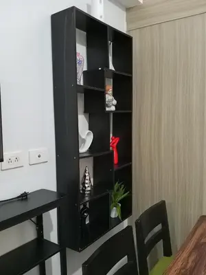 a black book shelf in a room with a table at MP shore 1 c2 unit 1567 in Manila