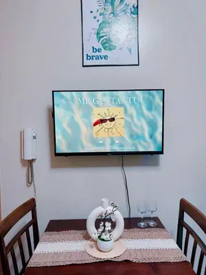 a dining room table with a tv on the wall at Shell Residences in Manila