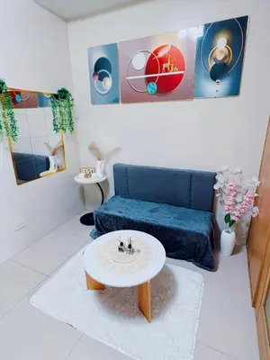 a living room with a blue couch and a table at Shell Residences in Manila
