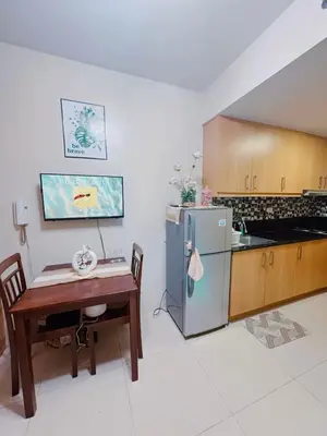 a kitchen with a table and a refrigerator at Shell Residences in Manila