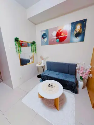 a living room with a blue couch and a table at Shell Residences in Manila