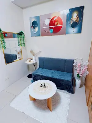 a living room with a blue couch and a table at Shell Residences in Manila