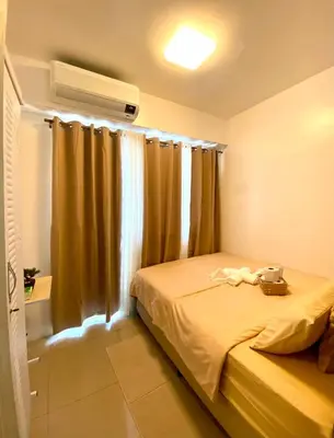 a bedroom with a bed and a window with curtains at Dayontabalay in Manila