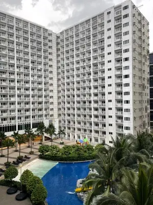 a large apartment building with a pool in front of it at Dayontabalay in Manila