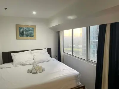 a bed with two teddy bears sitting on top of it at PrimeStay BGC in Manila