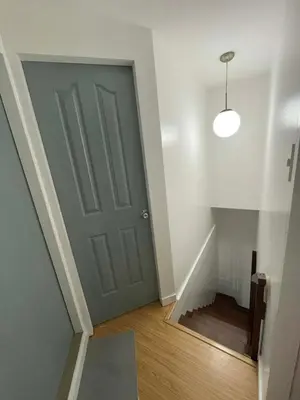 a hallway with a green door and a stairwell at PrimeStay BGC in Manila