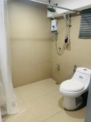 a bathroom with a toilet and a shower at PrimeStay BGC in Manila