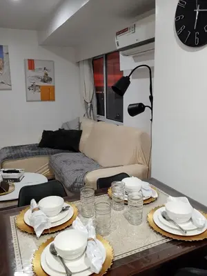 a living room with a table with dishes on it at PrimeStay BGC in Manila