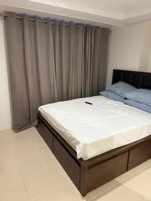 a bed in a bedroom with avertisementatronatronatronstrationstrationstration at Stylish New Condo at Covent Garden Sta Mesa in Manila