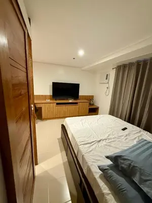 a bedroom with a bed and a flat screen tv at Stylish New Condo at Covent Garden Sta Mesa in Manila