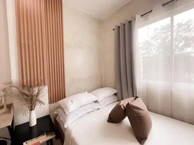 a bedroom with a bed and a large window at Boho Scandinavian with free Netflix, Wifi & Parking in Dasmariñas