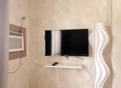 a flat screen tv on a wall with a vase at Boho Scandinavian with free Netflix, Wifi & Parking in Dasmariñas