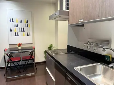 a kitchen with a sink and a counter top at The Gramercy Residences in Manila