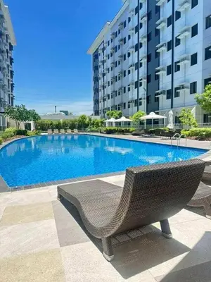 a swimming pool in front of a large building at Family Oasis at Leaf with Netflix in Muntinlupa in Manila