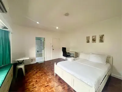 a bedroom with a white bed and a desk at Layover Guesthouse in Manila