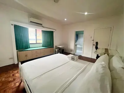 a bedroom with a large white bed and a window at Layover Guesthouse in Manila