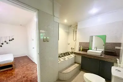 a bathroom with a shower and a toilet and a sink at Layover Guesthouse in Manila