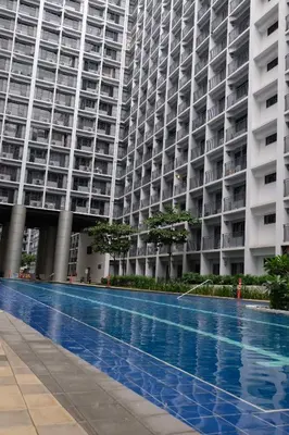a large building with a swimming pool in front of it at Urban Luxe Suite - Shore 2 Residences, Steps to Mall of Asia Complex, Pasay City in Manila
