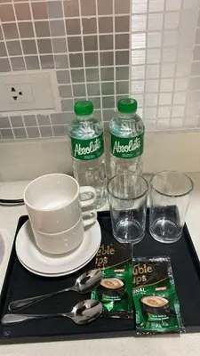 a tray with a bottle of water and a plate and glasses at Sunnyplace Residences Near NAIA Airport in Manila