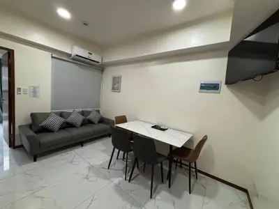 a living room with a couch and a table and chairs at Sunnyplace Residences Near NAIA Airport in Manila