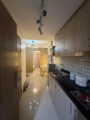 a kitchen with a sink and a counter top at Thrifty Comfy Luxe Stays in Manila