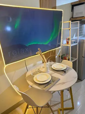 a table with two chairs and a table with green lights at Thrifty Comfy Luxe Stays in Manila