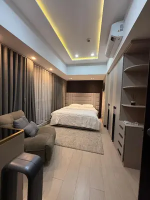 a bedroom with a bed and a couch at Cozy Apartment with Private Room in Vibrant Taguig in Manila