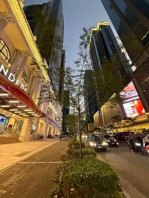 a city street with cars driving down the street at Cozy Apartment with Private Room in Vibrant Taguig in Manila
