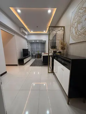 a large room with white tile flooring and a living room at Cozy Apartment with Private Room in Vibrant Taguig in Manila
